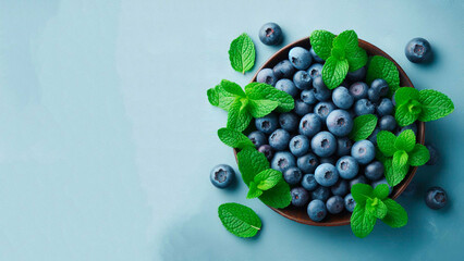 fresh ripe blueberries with mint leaves on a blue background