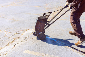 In course of worker patching patcher performs coated crack filling asphalt crack sealing bitumen...