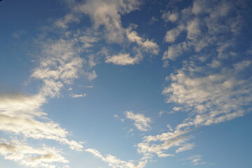 White fluffy clouds in the sky. Blue sky and cloud cover on a sunny summer day. Empty background,...