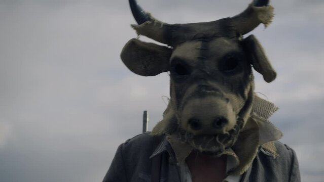 the monster walking along the road has a scary cow mask and the uniform of a German Wehrmacht soldier on his head