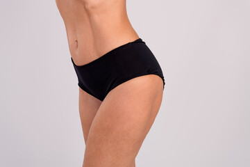 Cropped photo of skinny waist sporty lady legs hips abdomen muscle empty space isolated on grey color background