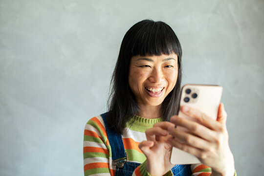 Close up smiling woman touching smartphone
