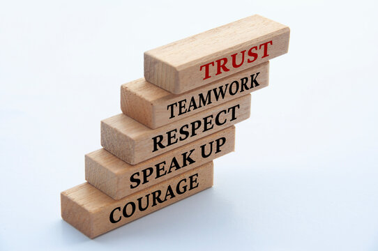 Courage, speak up, respect, teamwork and trust text on stacked wooden blocks. Positive culture.