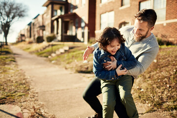 Joyful Father and Son Playing Together on a Sunny Suburban Street