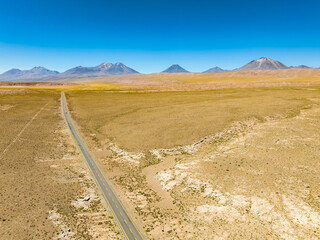 Região desértica ao lado do vilarejo de Socaire no Chile. Areia, dunas, céu azul e paisagem árida.