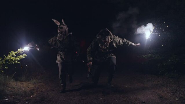 Soldier in a scary mask. 
A terrorist in a scary mask holds a lit flare. scary moment
