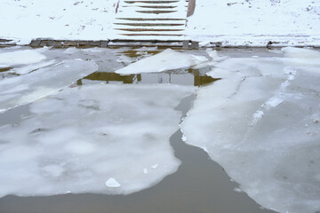 ice in river, lake, city reservoir, ice floes in dark water, ice blocks dangerous to cross, concept...