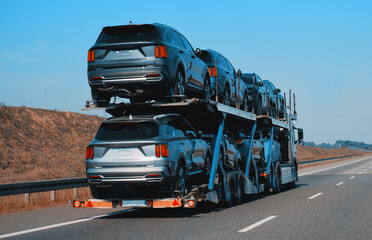 Car carrier trailer truck with brand new SUV cars for sale. New car delivery and shipping. Car...