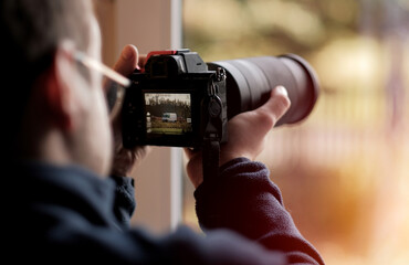 A Young Photographer Carspotter Trying To Catch A Vehicle In Motion In 4K Resolution Using His High-End Modern Luxury Mirrorless Full Frame Camera. Selective Focus
