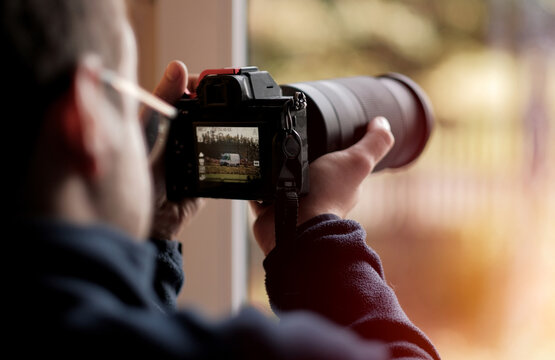 A Young Photographer Carspotter Trying To Catch A Vehicle In Motion In 4K Resolution Using His High-End Modern Luxury Mirrorless Full Frame Camera. Selective Focus