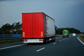 Modern Semi-Trailer Trucks On The Highway Driving In The Right Lane. Commercial Vehicle For Shipping And Post Delivery. Shipping Of The Goods On Land Door-To-Door