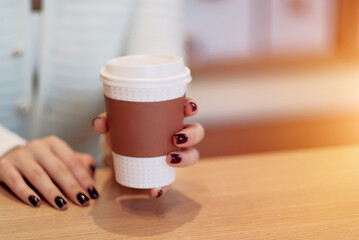 Hot Cappuccino. A woman holding a mug of coffee. Coffee rituals. The concept of the beginning of...