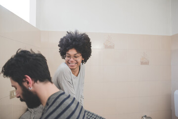 Young multiethnic millennials couple spending morning routine in bathroom together