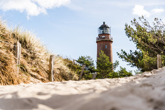 Lighthouse of Darsser Ort on German peninsula Darss with beach access in the foreground on a sunny day in autumn