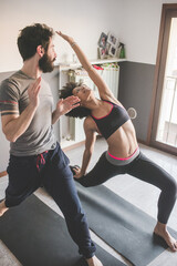 Multiethnic couple at home practicing sport doing fitness yoga