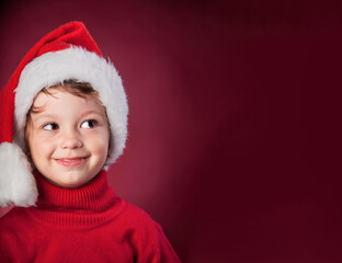 beauty boy in christmas hat on red background