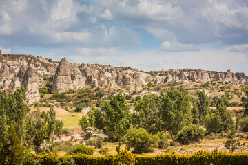 Fototapeta na wymiar Rocky landscape in Cappadocia, Turkey. Travel in Cappadocia. Unusual semi-desert mountain ranges. Amazing Rocky summer landscape with caves in Cappadocia Goreme