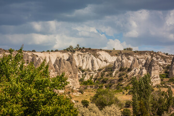 Fototapeta na wymiar Rocky landscape in Cappadocia, Turkey. Travel in Cappadocia. Unusual semi-desert mountain ranges. Amazing Rocky summer landscape with caves in Cappadocia Goreme