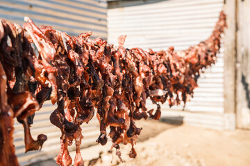 Strips of beef heads being dried for the consumption of local people, Katutura township, Windhoek, Namibia. These dried strips are difficult to digest and therefore provide long-lasting satiation. - obrazy, fototapety, plakaty