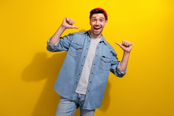 Photo of positive impressed guy wear denim jacket showing thumbs himself isolated yellow color...