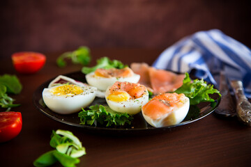 boiled eggs with salted red fish, herbs and seasonings in a plate .