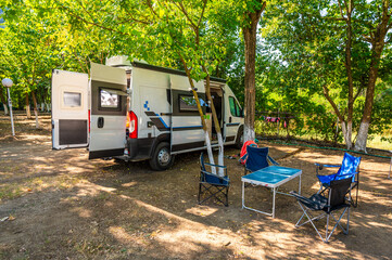 Campervan with camping equipment parked in the camping campsite.