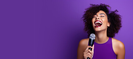 Young Woman Singing into a Microphone on a Purple Background with Space for Copy - obrazy, fototapety, plakaty