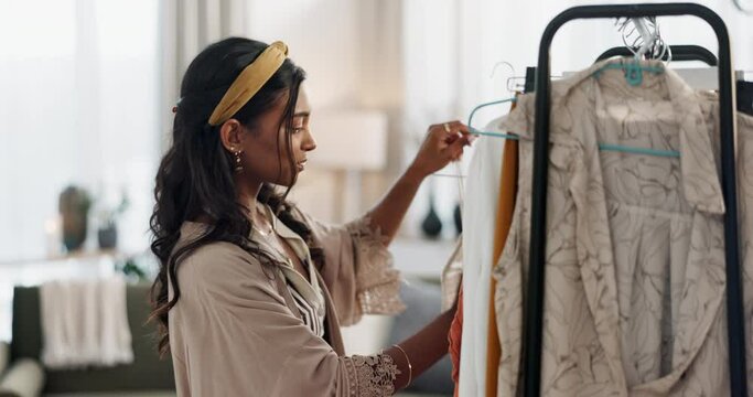 Woman, fashion designer and clothing rack in small business ecommerce or inspection at home. Creative female person looking at fabric, inventory or checking stock at retail boutique store for startup