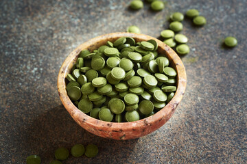Green barley grass tablets in a bowl on a table