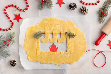 Fireplace cut inside dough. Christmas baking concept on grey background, new year decorations
