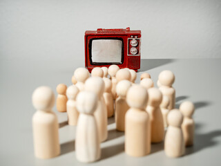 Wooden figures. A group of people are watching TV. The concept of media influence on people.