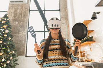 The kitchen sees a young, beautiful woman cooking while wearing a virtual reality headset.
