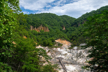 Fototapeta na wymiar Jigokudani, or named Hell Valley as the characteristic of hot steam vents, sulfurous streams and other volcanic activity, main source of Noboribetsu Onsen, Noboribetsu, Hokkaido, Japan