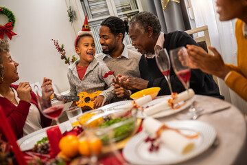 Family having fun on Christmas Eve by the table.