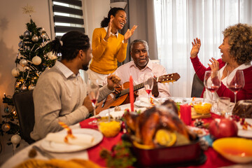 African American family playing guitar and singing  on Christmas Eve.