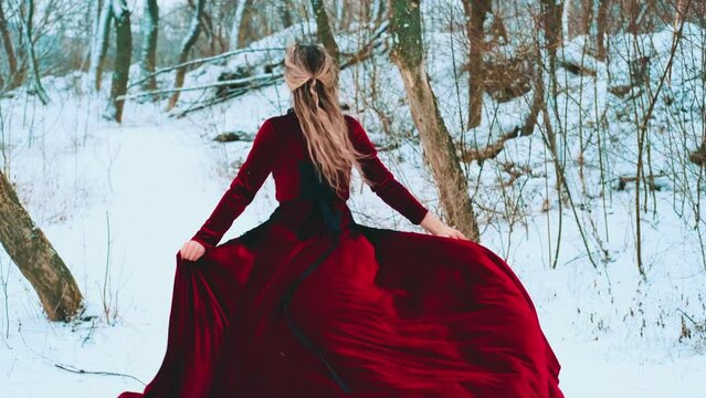 Fantasy happy woman smiling face running in deep forest dark tree covered frost, old style red train dress waving floats flies in wind. girl enjoys winter nature cold white snow. back rear view art 4k