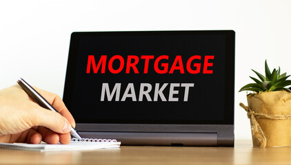 Mortgage market symbol. Concept words Mortgage market on beautiful black tablet. Beautiful white background. Businessman hand. Business mortgage market concept. Copy space.
