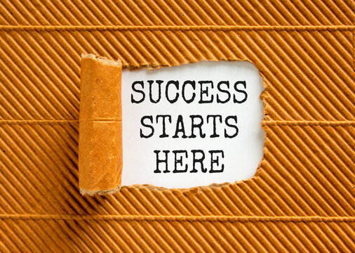 Success starts here symbol. Concept word Success starts here on beautiful white paper. Beautiful brown table brown background. Business motivational success starts here concept. Copy space.