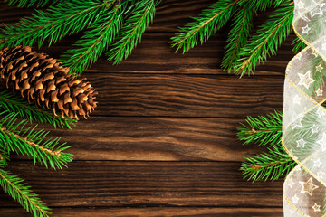 Christmas wooden background with green pine branches and cone. 