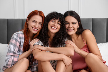 Obraz premium Portrait of happy young friends on bed at home