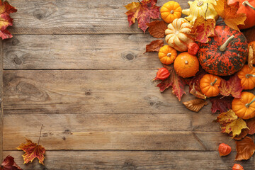 Dry autumn leaves and pumpkins on wooden table, flat lay. Space for text