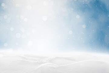 Sunlit snowdrifts and falling snow on a defocus blue background