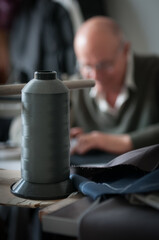 Unrecognized tailor using sewing machine, making modern clothes, Man at workshop, holding fabric, tailoring