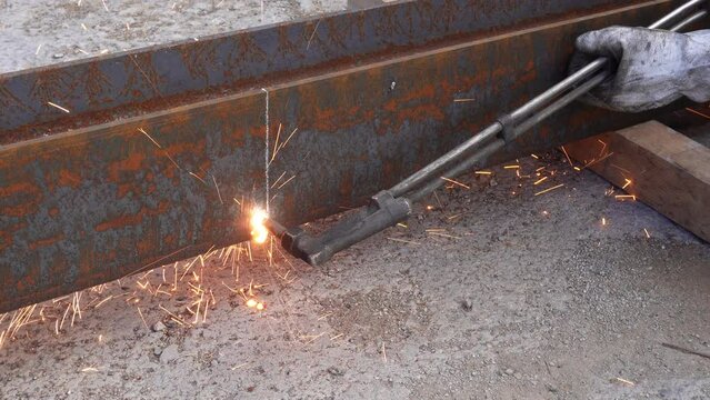 Gas cutter.
Welding, or gas welding in the USA, and oxy-fuel cutting of thick metal. A worker cuts metal with a cutting torch.
