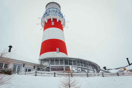 Lighthouse in winter in a fishing village, lighthouse in a blizzard