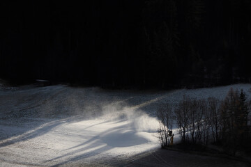 Snowmaking machine snow cannon or gun in action on a cold sunny winter day in Dolomites