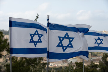 Blue and white flags of the State of Israel flutter in the breeze on Mount Herzl in Jerusalem. 