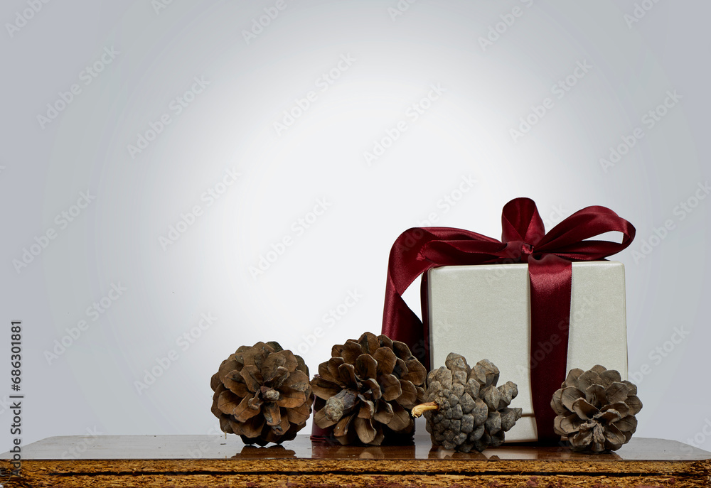 Wall mural Christmas and new year background - gift box with pine cone on wooden table 