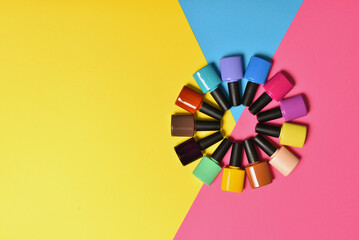 Obraz premium Colorful nail polishes bottles on a blue background