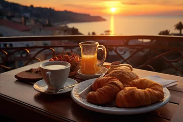 cup of coffee and french croissant on table, balcony with view of beautiful landscape, still life, sea and mountains, resort town, sunset © soleg